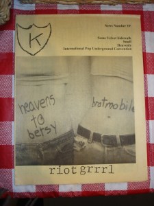 K fue un fanzine relacionado con K Records, un sello fundado por Calvin Johnson, un DJ de KAOS. Fue Johnson quien le pidió a Tobi Vail montar un grupo, cuando ella tenía 15 años. Esto dio lugar a la formación de Go Team, en el que ella era la baterista.